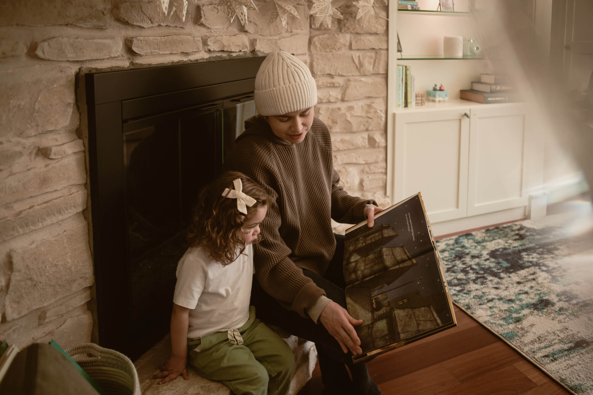 Family reading to their toddler in the living room during their indoor family photoshoot