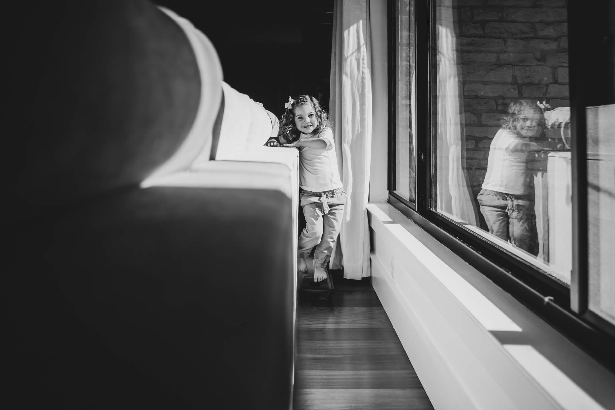 toddler playing chasing with her parents in the living room