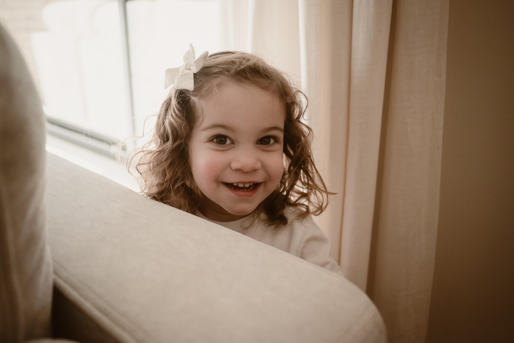 toddler playing chasing with her parents in the living room