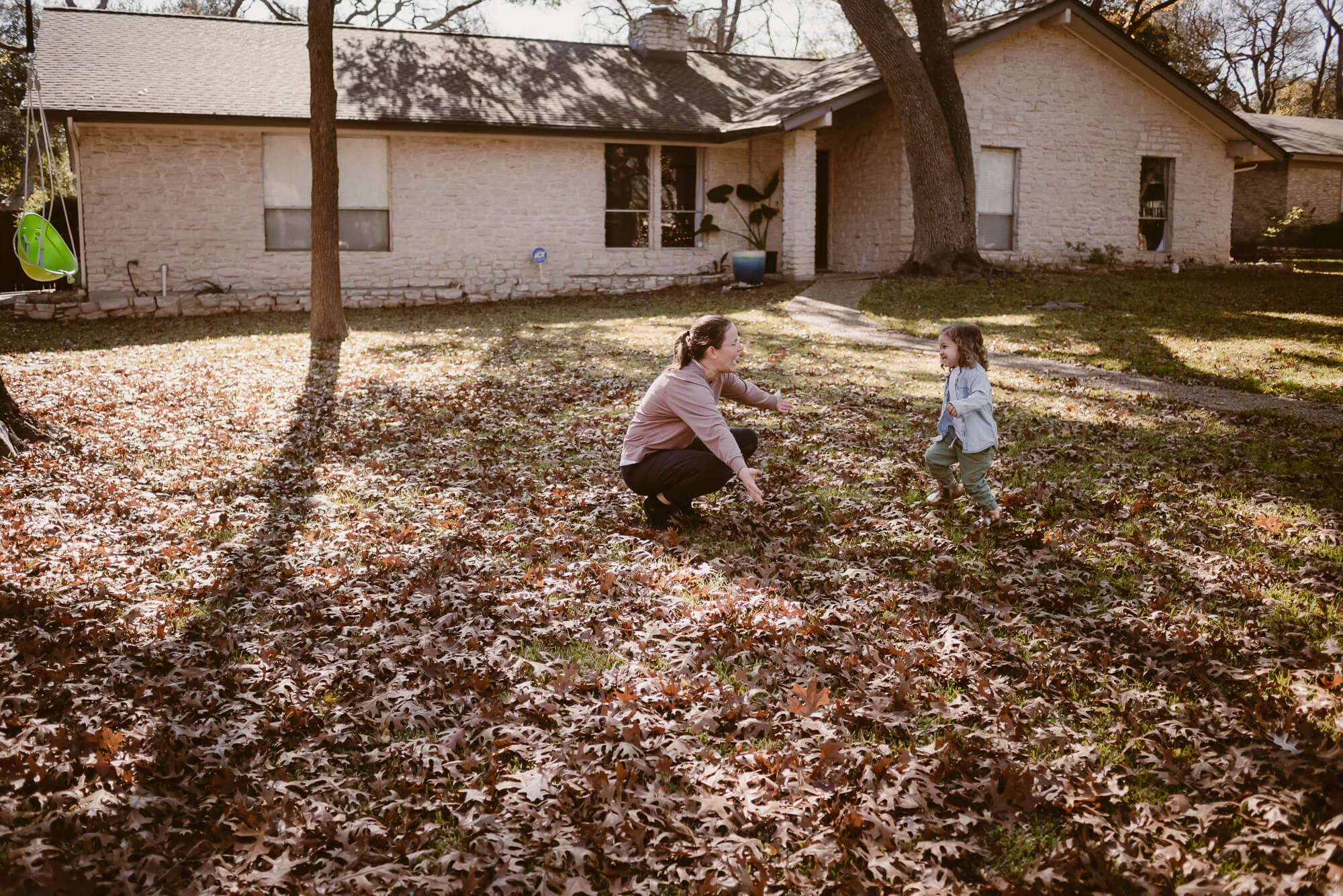 toddler running into her parent's arms during an at home family photoshoot in austin texas