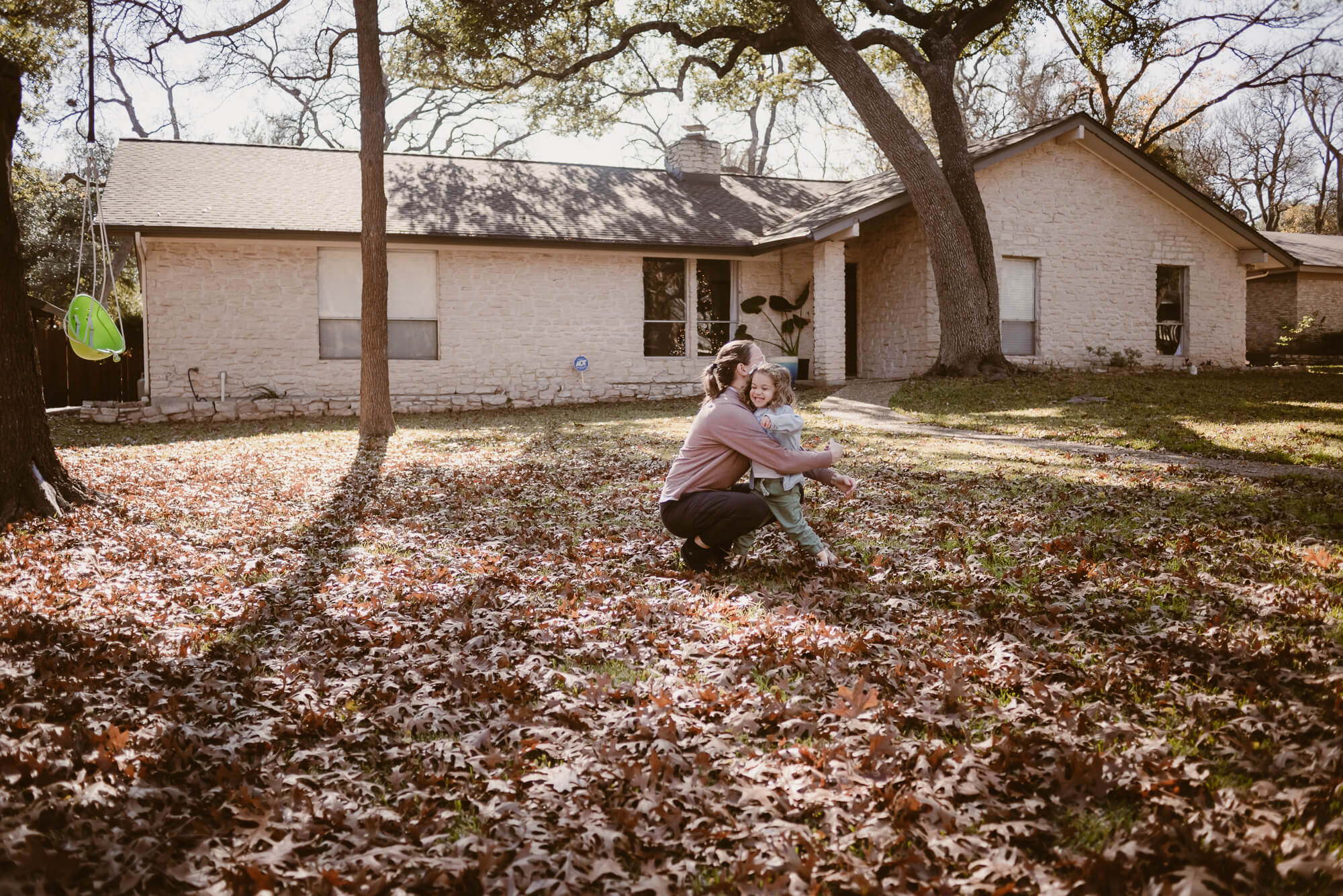 toddler running into her parent's arms during an at home family photoshoot in austin texas