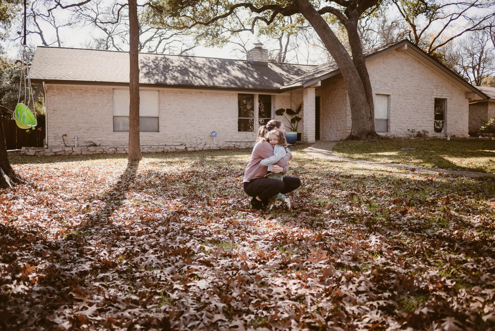 toddler running into her parent's arms during an at home family photoshoot in austin texas