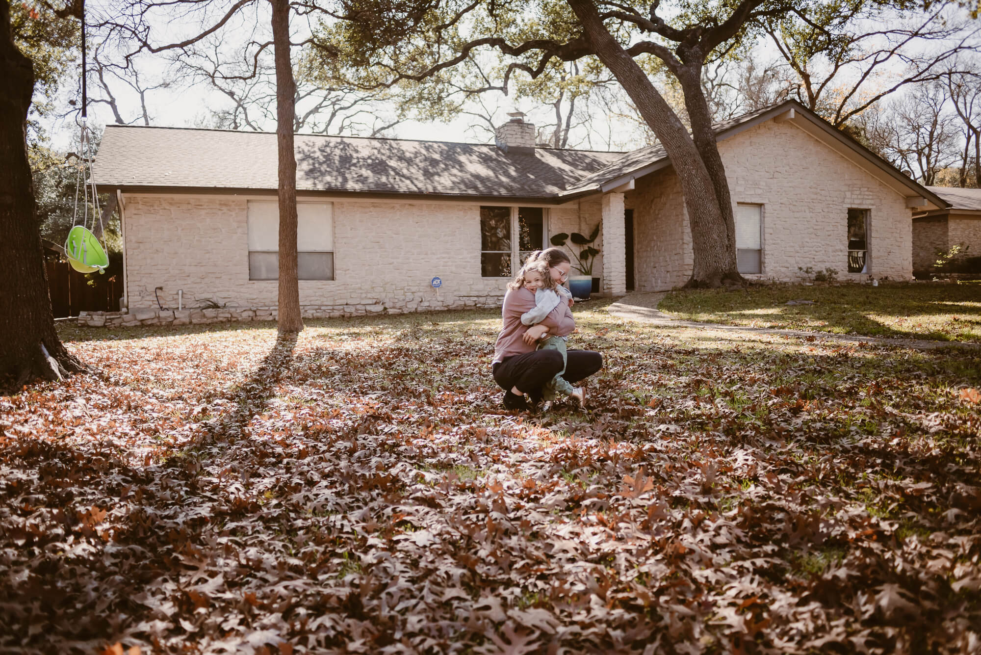 toddler running into her parent's arms during an at home family photoshoot in austin texas